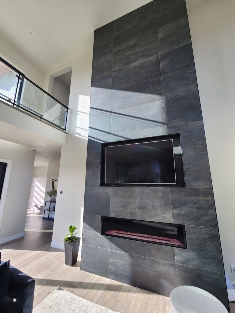 Modern fireplace wall with large-format dark tile, linear fireplace, and integrated TV