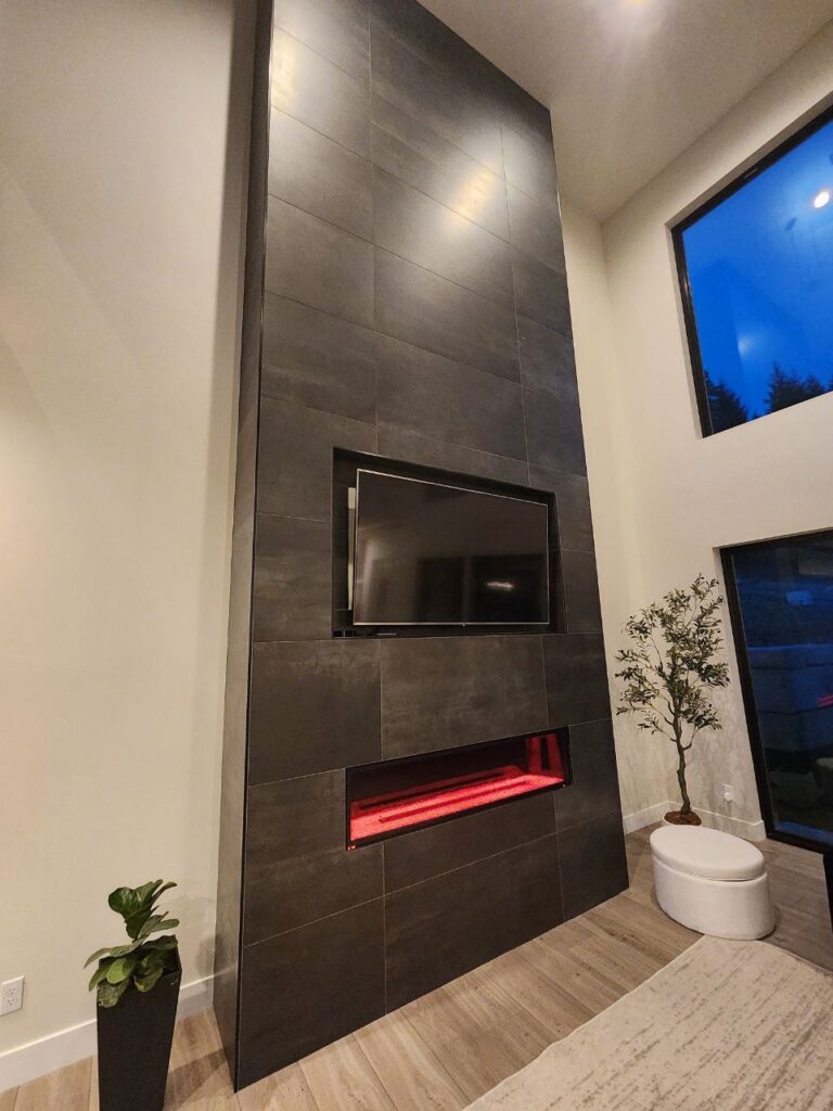 Living room fireplace remodel with tall tiled feature wall and sleek built-in television