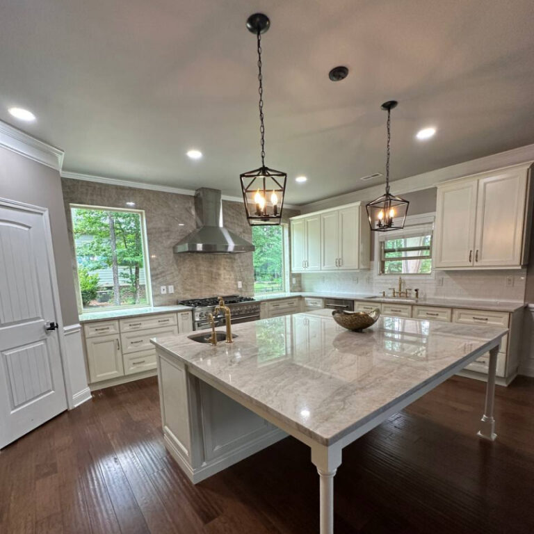 Bright classic kitchen remodel with large island, soft-toned cabinetry, and brass accents