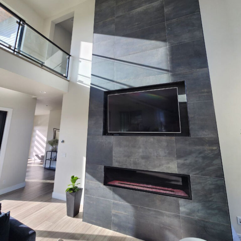 Modern fireplace remodel with tall dark tile feature wall, linear fireplace, and integrated TV