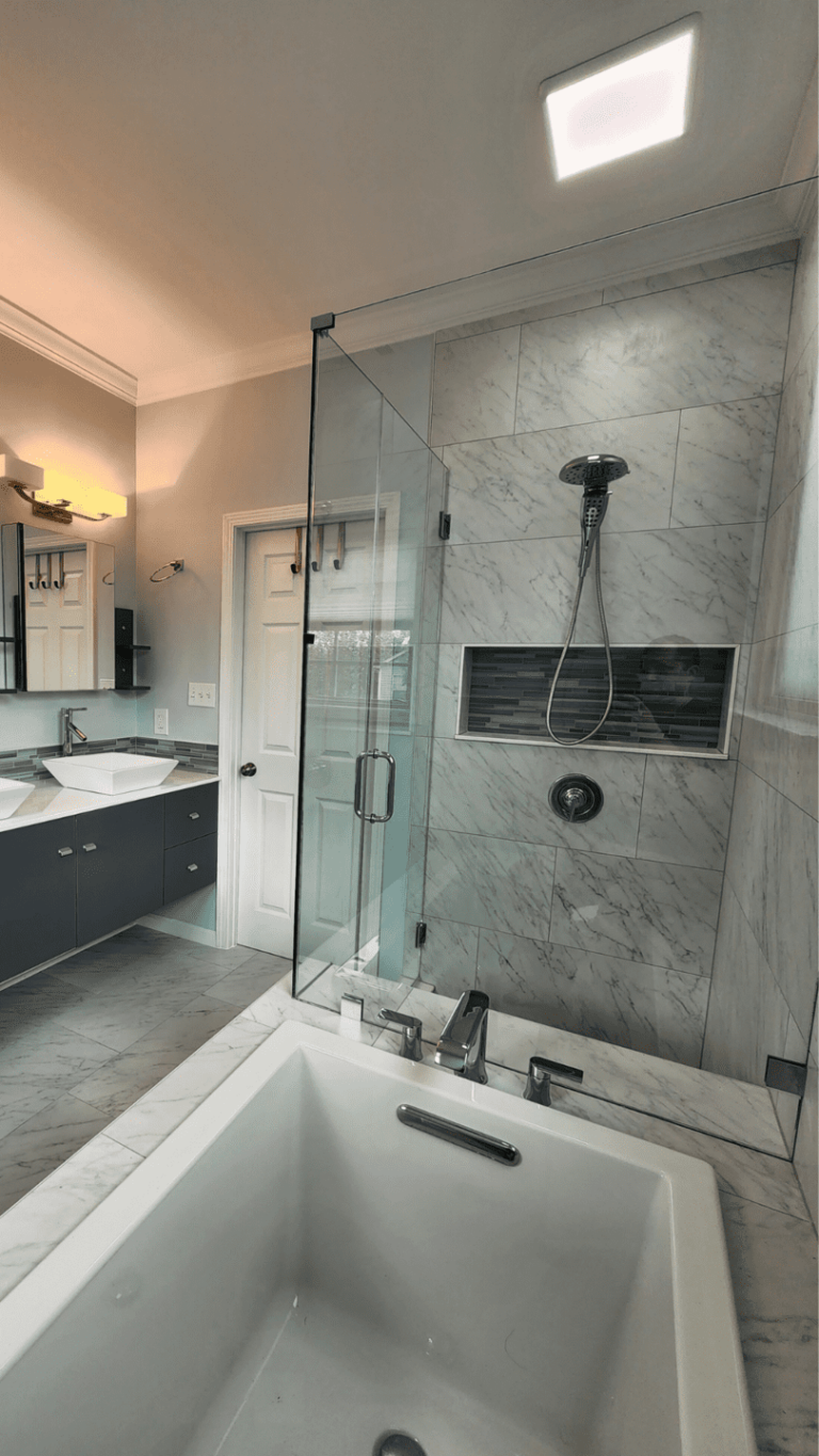 Open bathroom remodel with frameless glass shower, built-in tub, and double vanity
