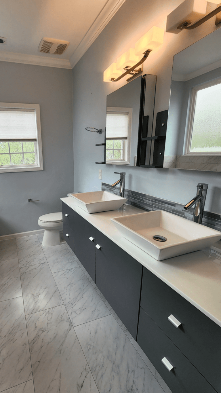 Spacious bathroom with vessel sinks, marble-look tile, and glass shower enclosure