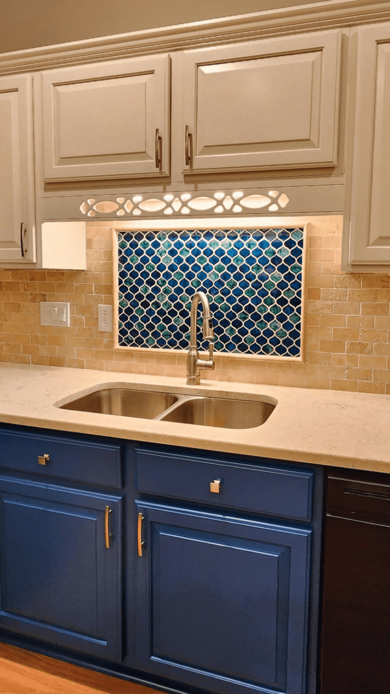 Two-tone kitchen with blue lower cabinets, white upper cabinets, and warm wood flooring