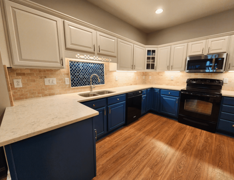 Blue and white kitchen remodel with light countertops and decorative backsplash tile