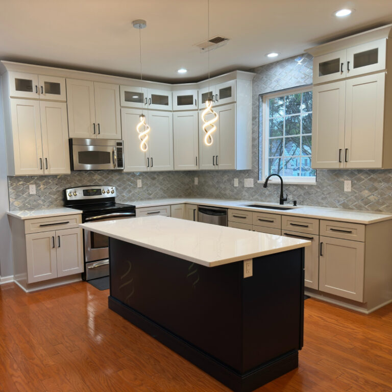 Two-tone kitchen remodel with large island, textured backsplash, and modern pendant lighting