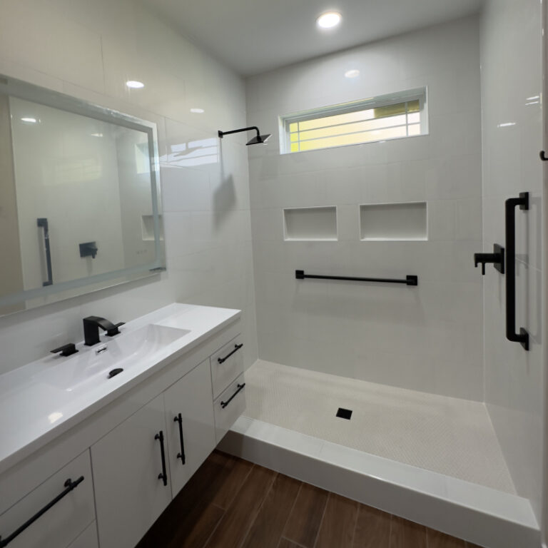 Minimal bathroom remodel with walk-in shower, white vanity, and tall built-in storage