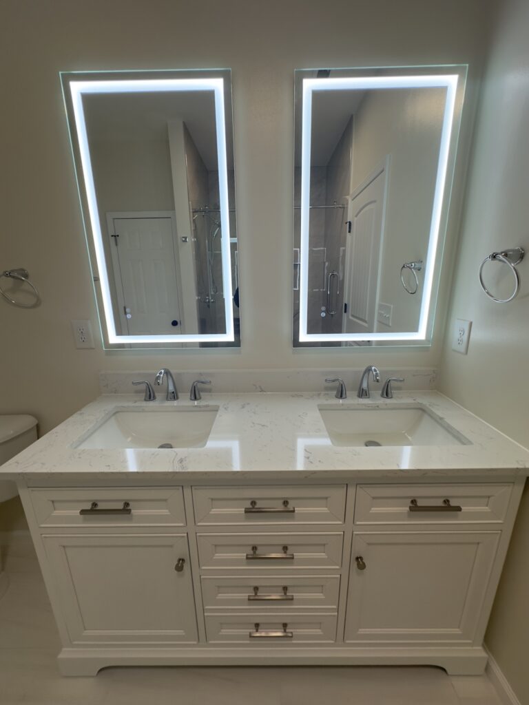 Bathroom remodel with neutral tile, safer shower access, and modern double-sink vanity