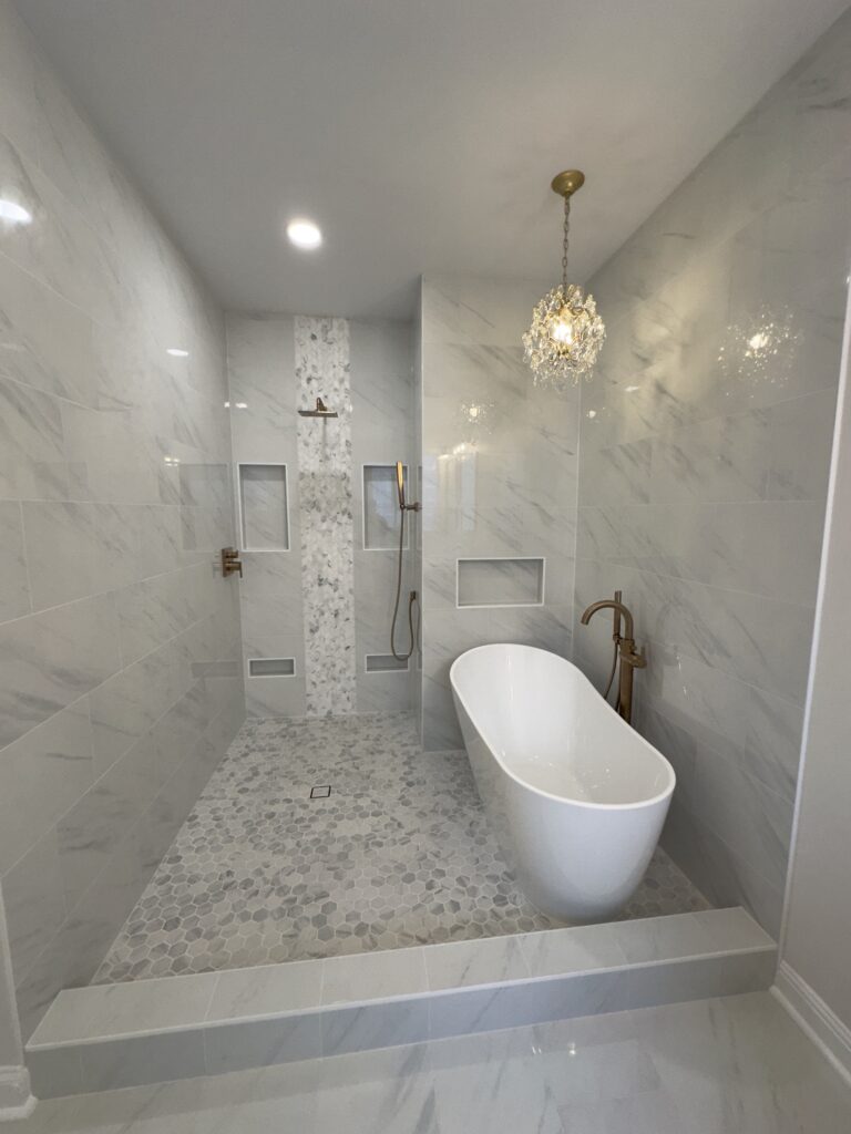 Luxury bathroom with soaking tub, built-in niches, and chandelier over wet room shower area