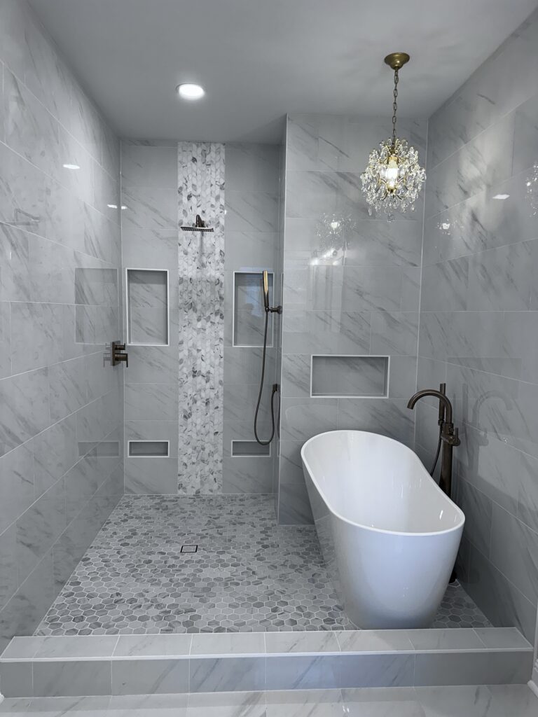 Elegant wet room bathroom with freestanding tub, walk-in shower, and marble-look tile