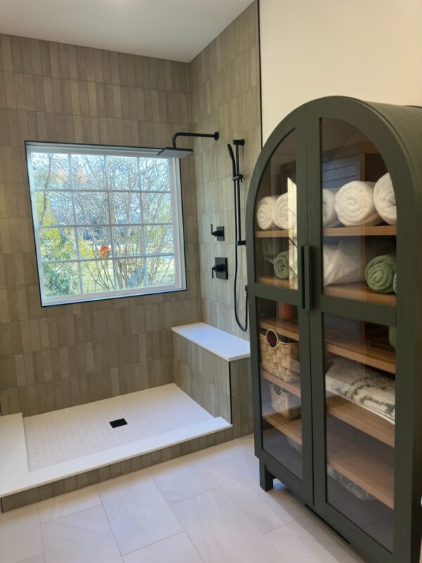 Spa-inspired bathroom with walk-in shower, double vanity, and built-in storage