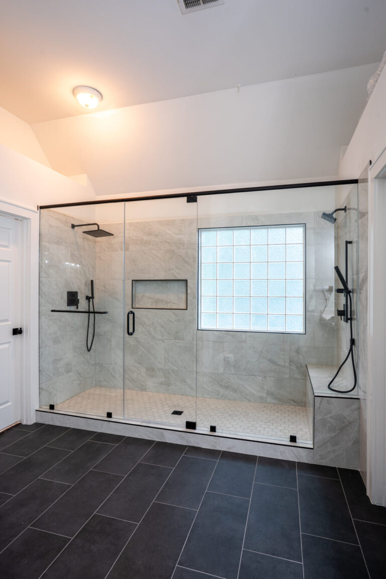 Modern bathroom with open shower area, soaking tub, and dark fixture contrast