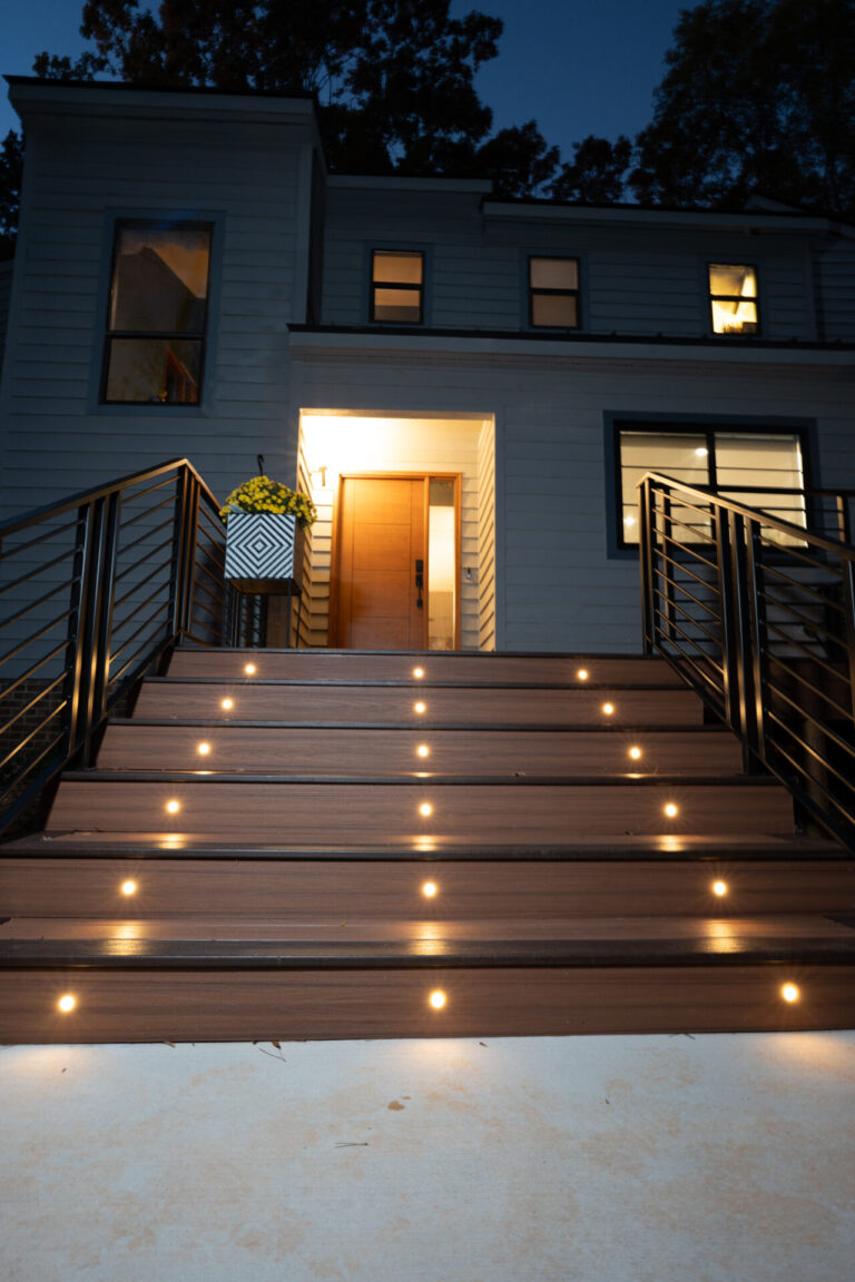 Outdoor deck remodel with built-in step lighting and modern metal railings