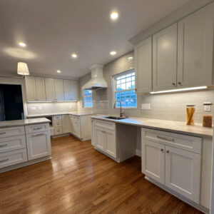 Classic kitchen remodel with white shaker cabinetry, large island, and warm wood flooring