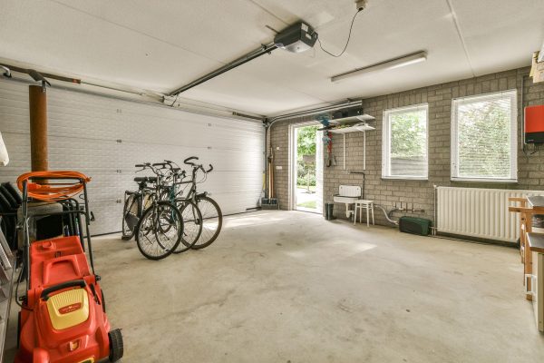 Amsterdam, Netherlands - 10 April, 2021: a garage with two bikes parked in front of the garage door and an electric heater hanging on the wall